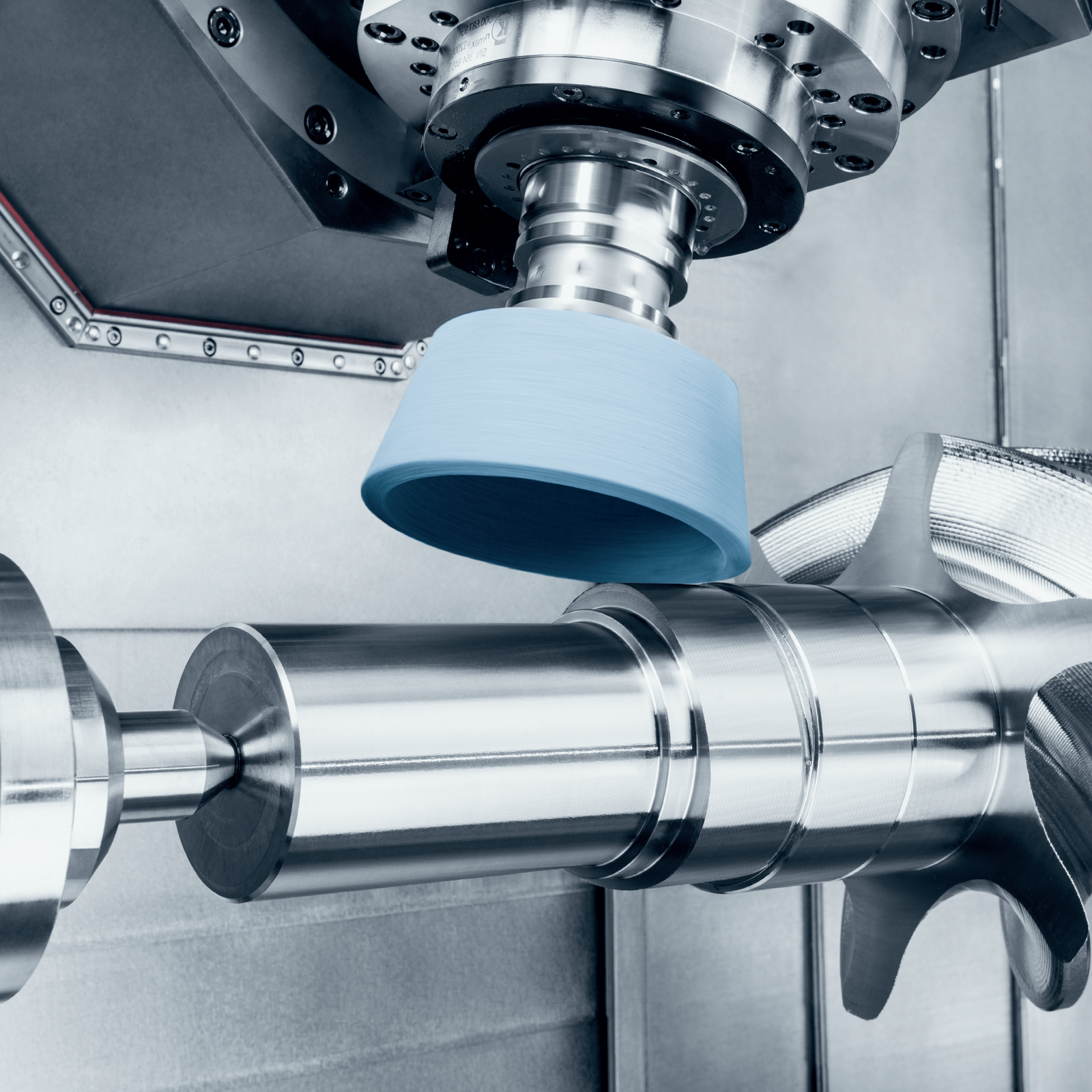 Industrial factory workers operating machinery in a large factory with blue and orange lighting